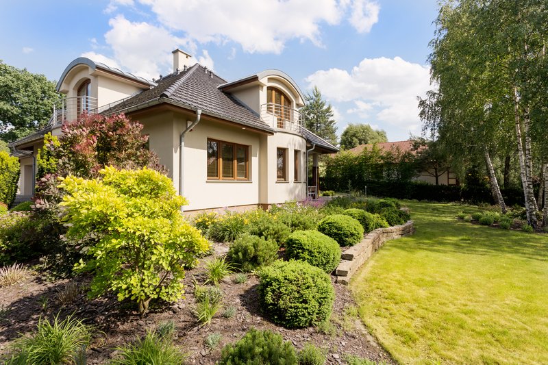 fotografia de casa moderna en una tarde asoleada con un jardin